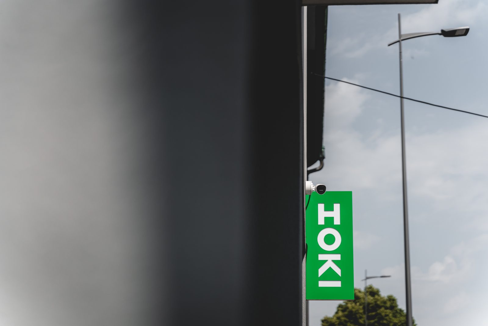 Venkovní cedule HOKI na fasádě showroomu