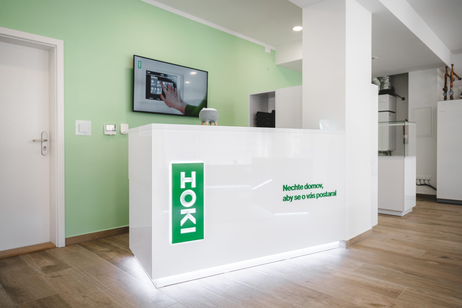 Recepce showroomu HOKI HOME s logem a claimem značky